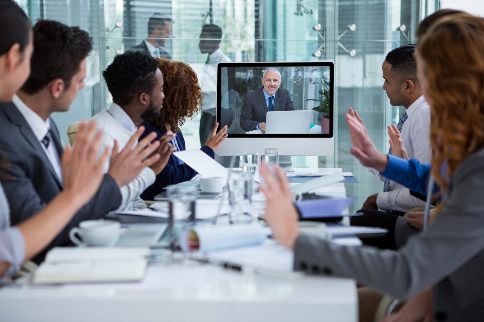 Business people looking at a screen during a video conference Hugh's